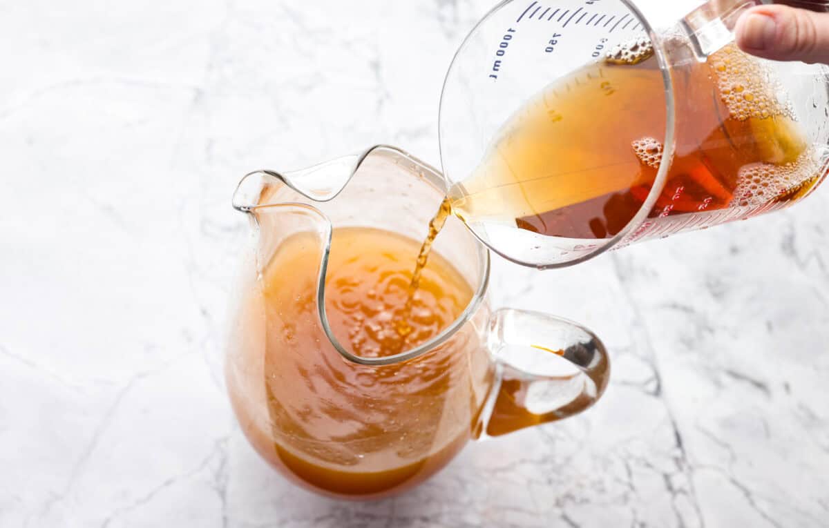 If you love iced tea, you’re going to be obsessed with this Arnold Palmer. The combo of crisp black tea and tangy lemonade is pure summer magic. It’s simple, refreshing, and always just what you need. Someone pouring unsweetened black tea into the pitcher with lemon juice and sugar.